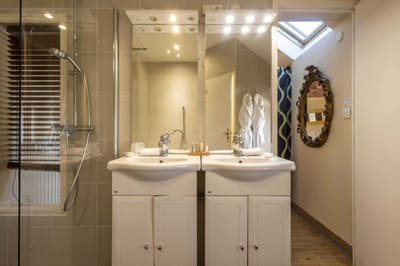 Chambre Amazone : double vasque sous miroirs lumineux, douche vitrée et lucarne