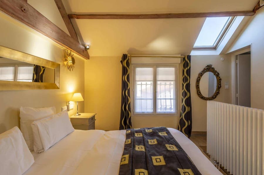 Chambre Amazone : lit face à la fenêtre, lucarne de toit et miroir ovale doré