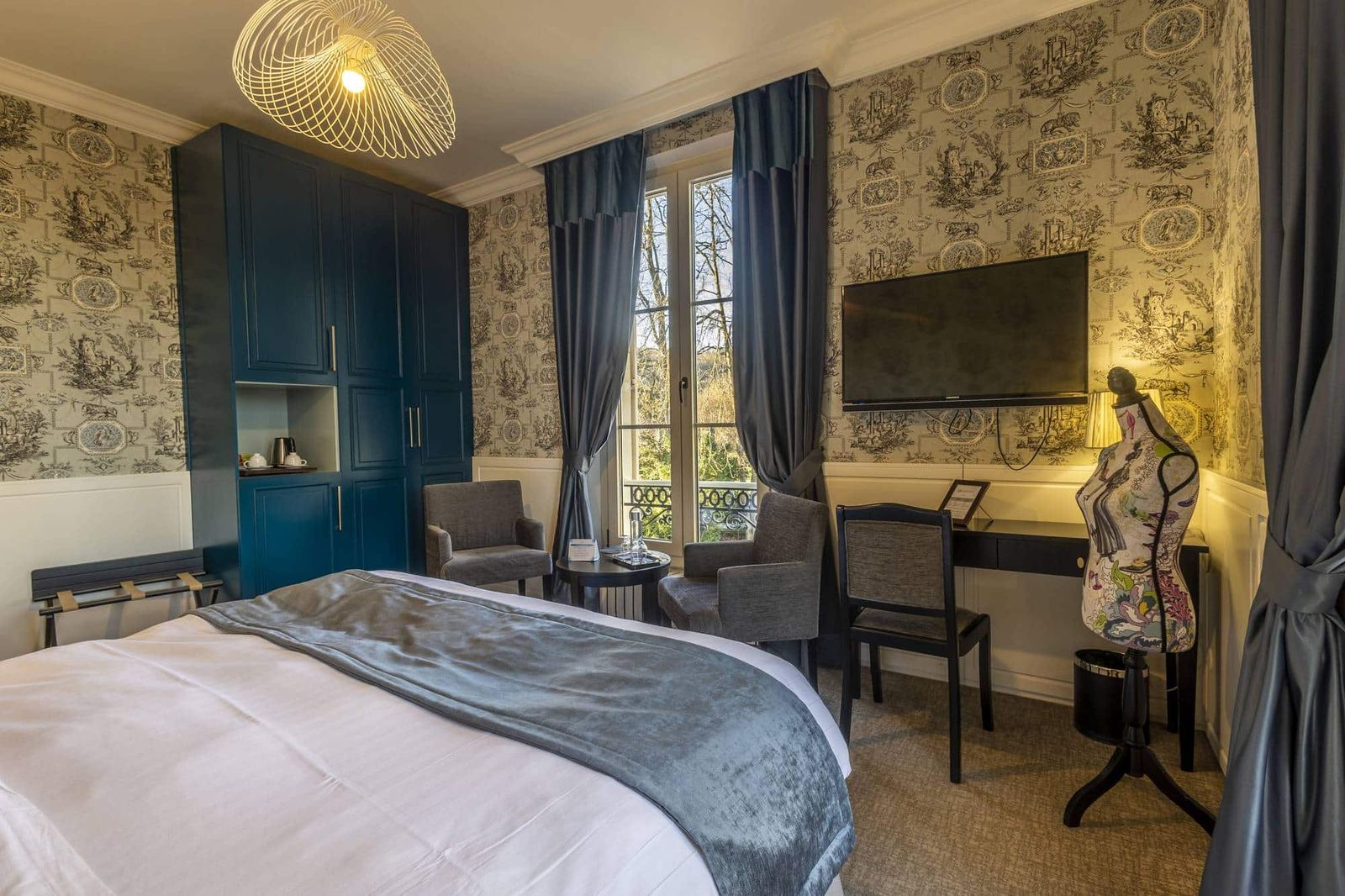 Chambre Bleue : armoire bleu nuit, toile de Jouy, bureau et fauteuils devant la fenêtre