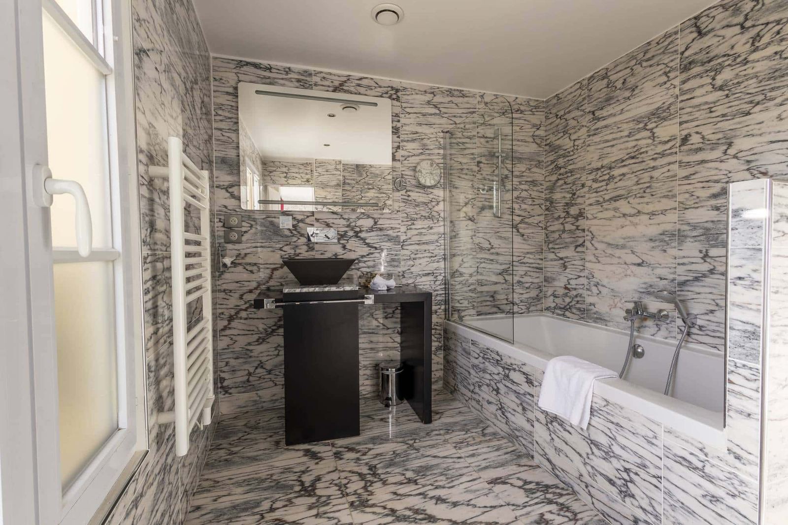Chambre Coquelicot : marbre gris du sol au plafond, vasque noire, baignoire et fenêtre