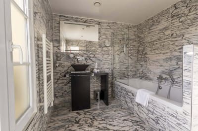 Chambre Coquelicot : marbre gris du sol au plafond, vasque noire, baignoire et fenêtre
