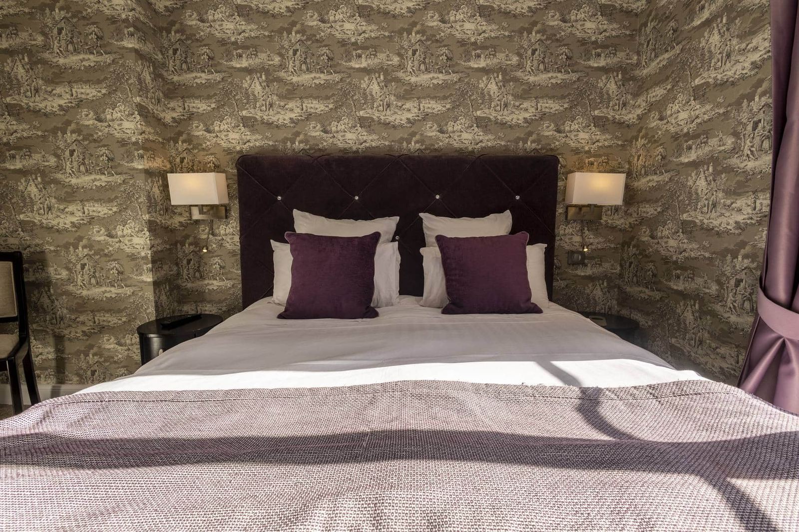 Chambre Coquillage : tête de lit en velours prune, coussins assortis, appliques et toile de Jouy
