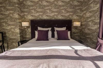Chambre Coquillage : tête de lit en velours prune, coussins assortis, appliques et toile de Jouy