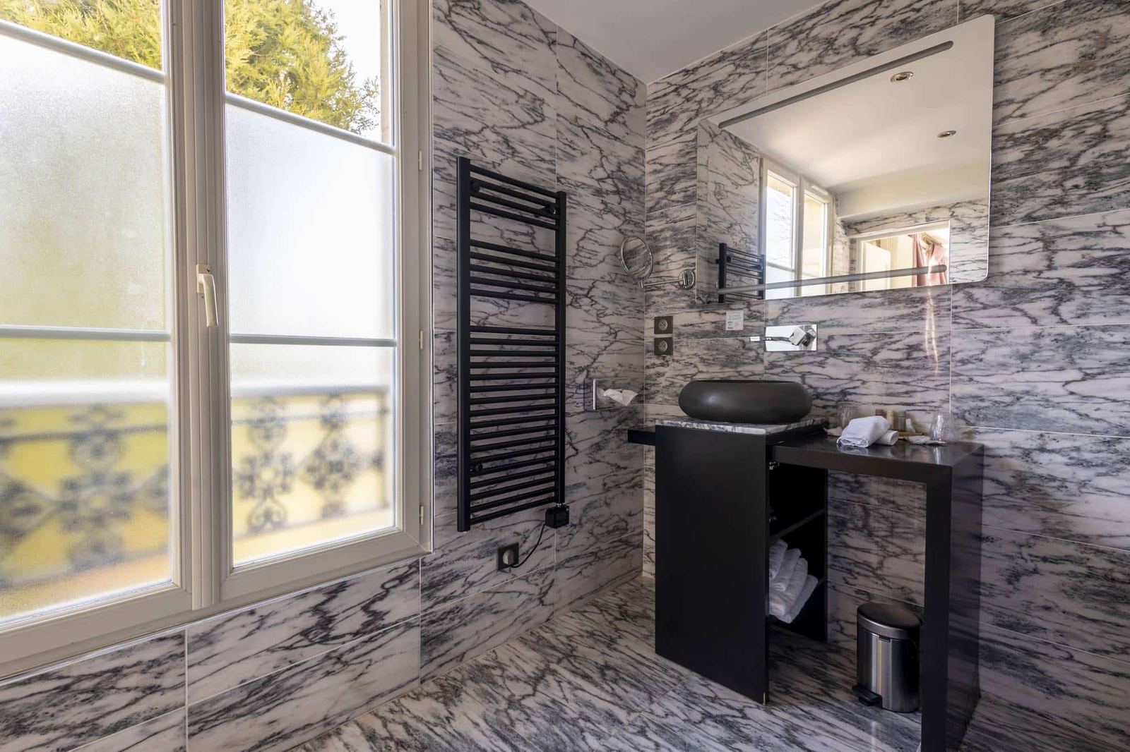Chambre Coquillage : salle de bains en marbre gris, fenêtre dépolie, sèche-serviettes noir et vasque