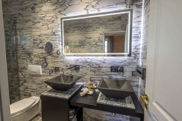 Chambre Romantique : deux vasques noires sous un miroir rétroéclairé, marbre veiné