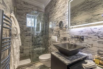 Chambre Romantique : douche vitrée à fenêtre, vasque noire et peignoirs sur marbre veiné