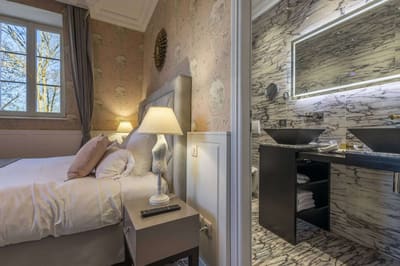 Chambre Romantique : lampe de chevet, fenêtre sur les arbres et salle de bain en marbre veiné