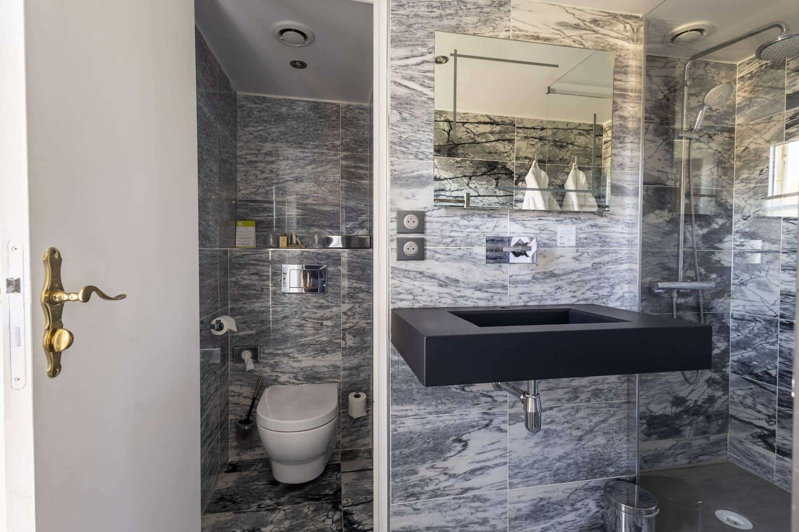 Chambre Vue sur Ferme : salle de bain en marbre gris, vasque noire, douche vitrée et toilettes séparées