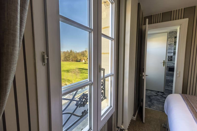 Chambre Vue sur Ferme : fenêtre ouverte sur la prairie et les arbres, garde-corps en ferronnerie