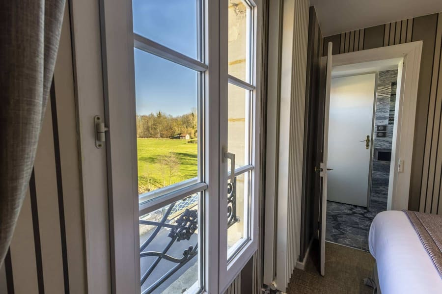 Chambre Vue sur Ferme : fenêtre ouverte sur la prairie et les arbres, garde-corps en ferronnerie