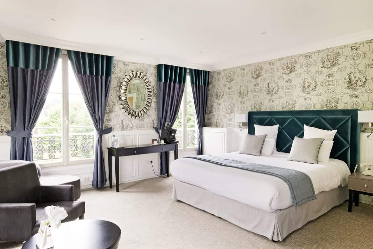 Suite Marquise : lit à tête capitonnée bleu canard, toile de Jouy et fenêtres à balconnet