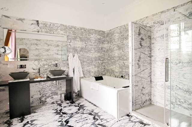 Suite Royale : salle de bains en marbre, jacuzzi, douche vitrée et double vasque noire