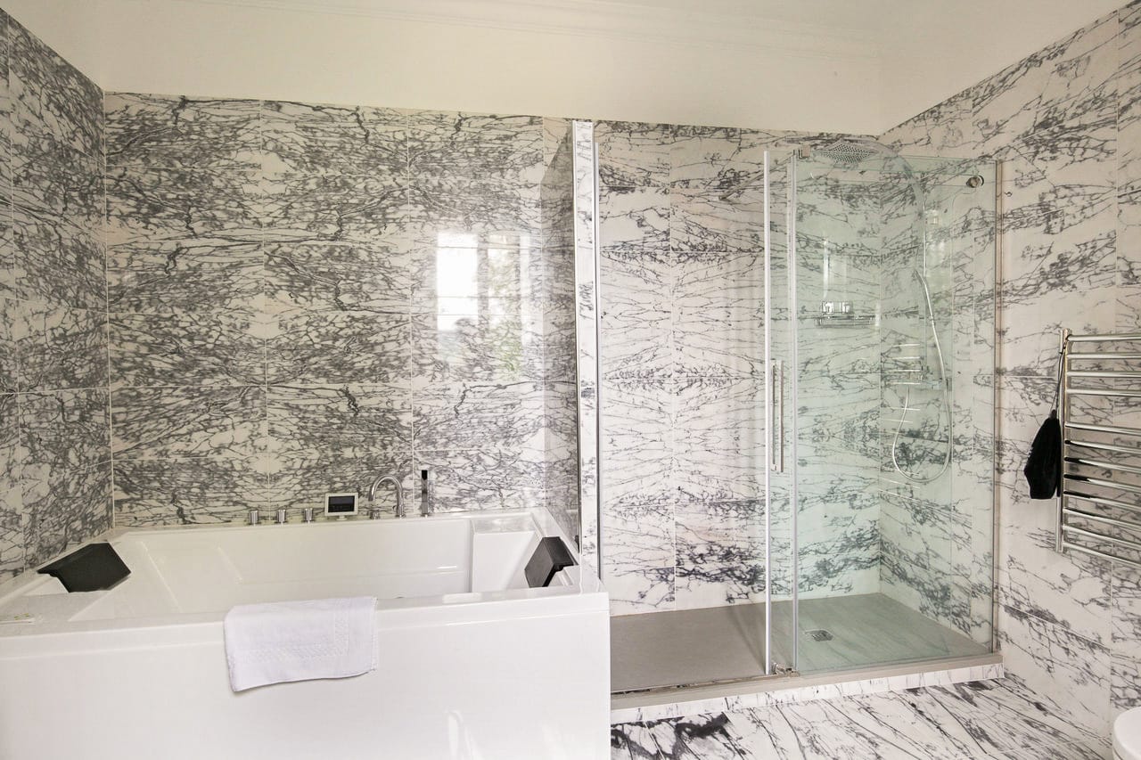 Suite Royale : jacuzzi à appuie-têtes et douche vitrée, murs et sol en marbre veiné