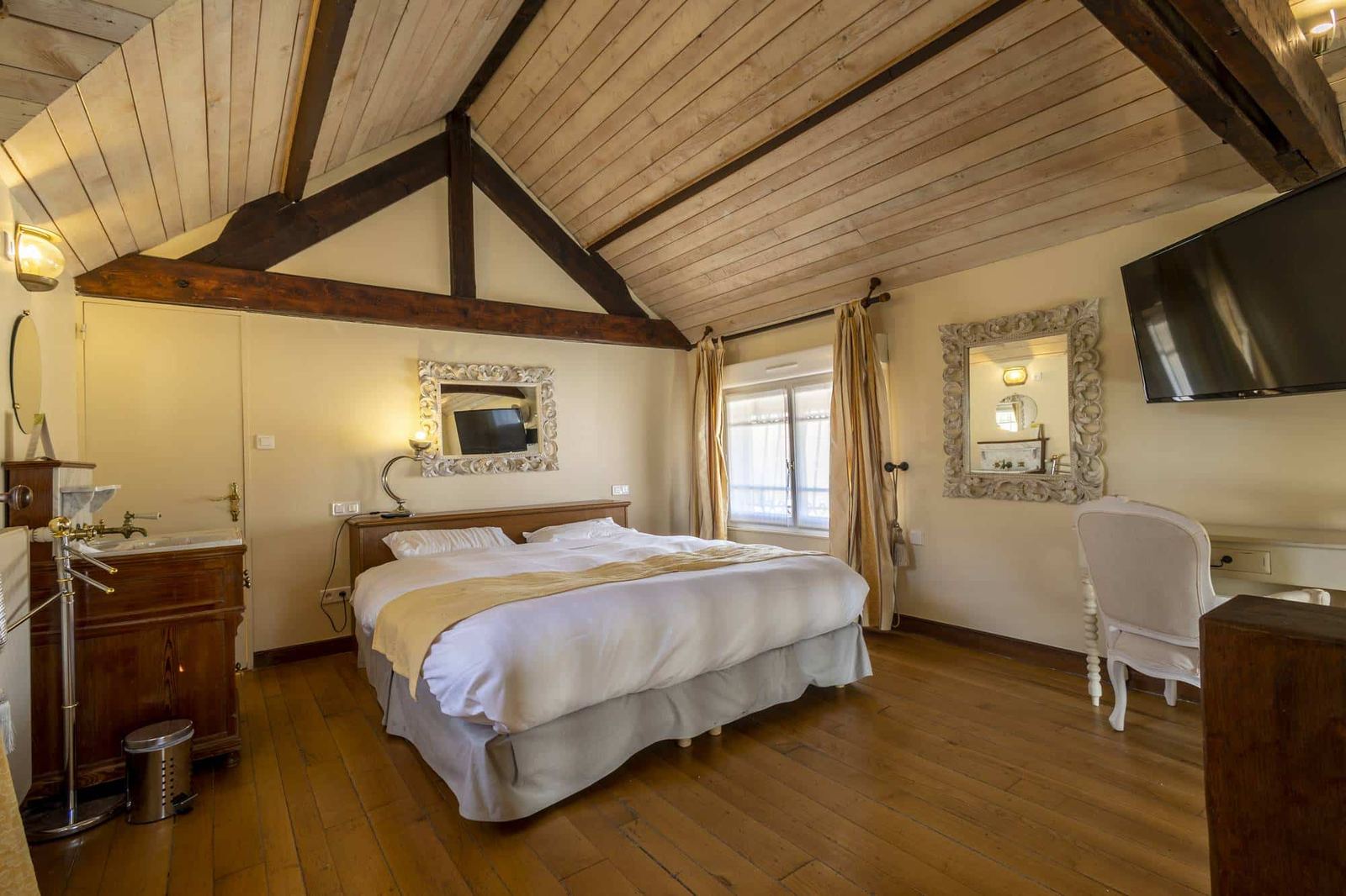 Suite Familiale Licorne : chambre mansardée au plafond de bois blanchi, lit, parquet et lavabo ancien