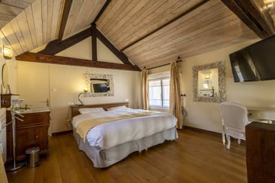 Suite Familiale Licorne : chambre mansardée au plafond de bois blanchi, lit, parquet et lavabo ancien