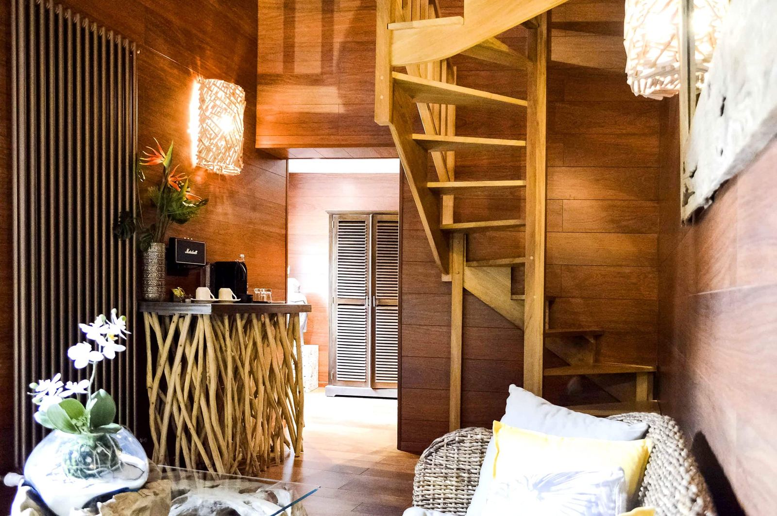 Suite Indonésienne : escalier en bois, console en bois flotté et canapé en rotin