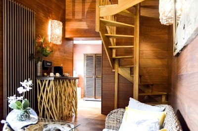 Suite Indonésienne : escalier en bois, console en bois flotté et canapé en rotin