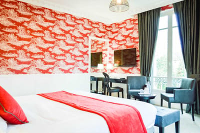 Suite Princière : toile de Jouy rouge, lit, bureau et fauteuils devant la fenêtre